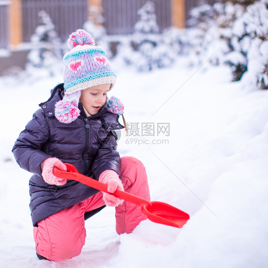 小女孩在冬日里玩铲雪图片