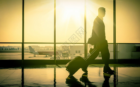 阳光直射，机场男乘客走进现代生活背景图片