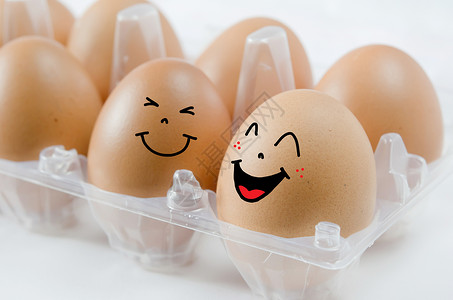 白色背景包装中的快乐棕色鸡蛋图片