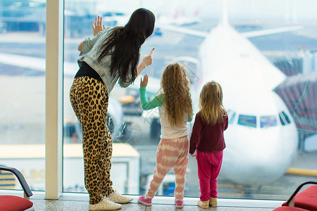 可爱的小女孩和妈在机场的大窗户图片