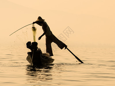 缅甸茵莱湖传统缅甸渔民在回收渔网时在图片