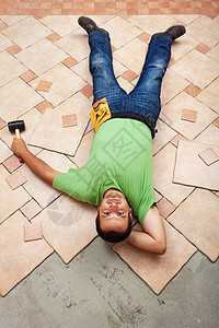 男人在陶瓷地板砖上休息他正在安装图片