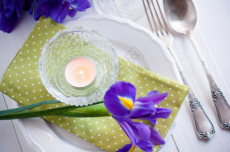 带有紫色鸢尾花复古餐具和蜡烛的节日餐桌布置图片