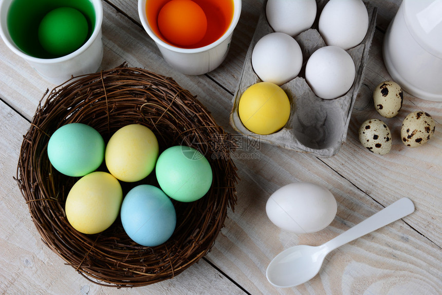 垂死的复活节彩蛋的高角度视图用染料溶液中的鸡蛋和其他准备浸泡的鸡蛋在巢中染色乡村农舍风格厨房餐桌图片