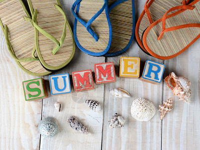 孩子们在生锈木板上拼写夏日的街区这个词被海壳和翻滚式凉鞋环绕图片