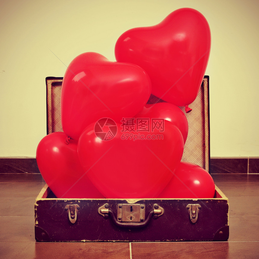 红色心形气球堆在一个旧手提箱里图片