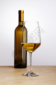 一瓶白葡萄酒桌上放着玻璃杯图片