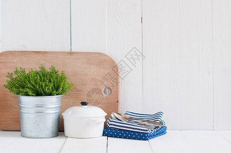 金属锅中的室内植物陶器餐具和白漆板上的餐巾图片