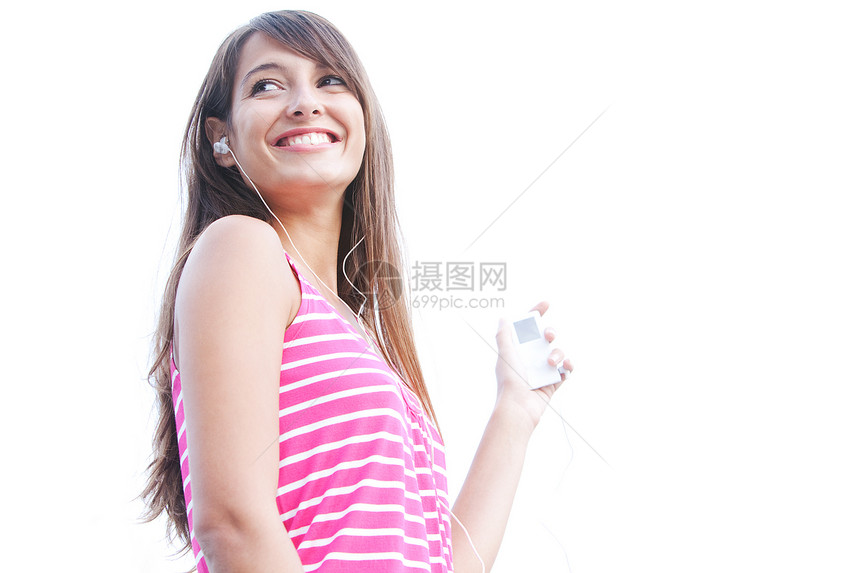 一个迷人的年轻女子用她的mp3播放器和小耳机听音乐图片