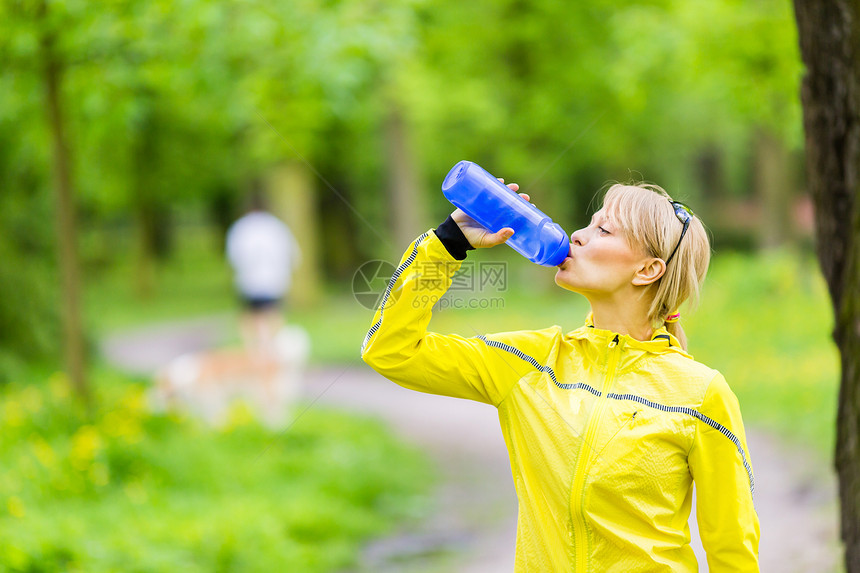 美丽的女选手在跑步和走在公园夏季大自然露明森林户外锻炼时图片