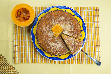 黄色桌布上的自制椰子和南瓜蛋糕图片
