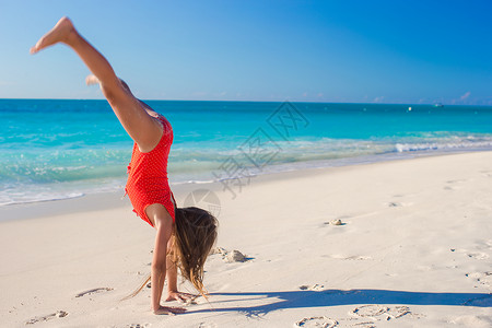 美丽的体操小女孩在沙滩图片