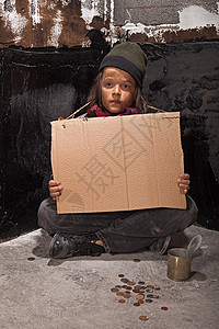 街上可怜的乞讨小男孩手持纸板牌的白瞪着眼图片