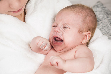 年轻母亲与可爱新生婴儿在家中玩乐照顾孩子幸福父母爱的概念的近图片