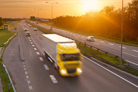 黄昏高速公路高峰时段的黄色卡车图片