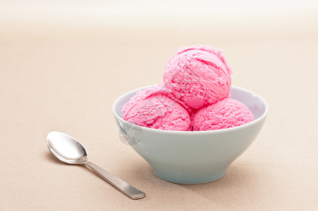 在米色背景的草莓冰淇淋杯图片