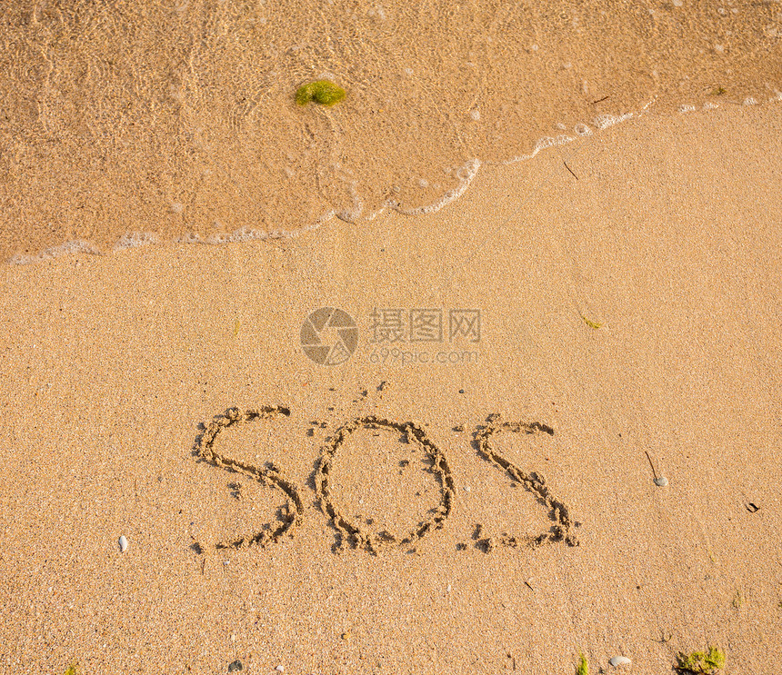SOS用手指或棍子在沙中写作的图片