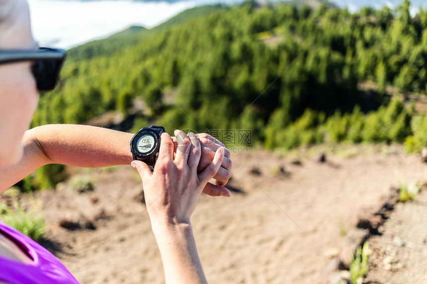 山路上的田径跑者或徒步登山者在看体育手表检查能或心脏脉搏图片