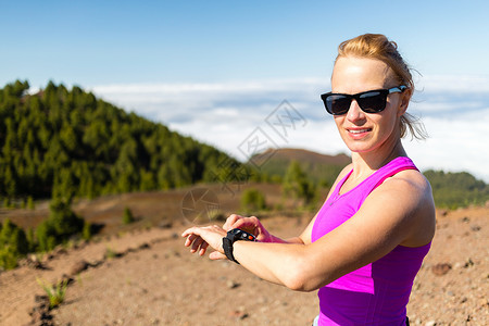 山中的越野跑者或徒步旅行者查看手表检查能或心脏脉搏图片