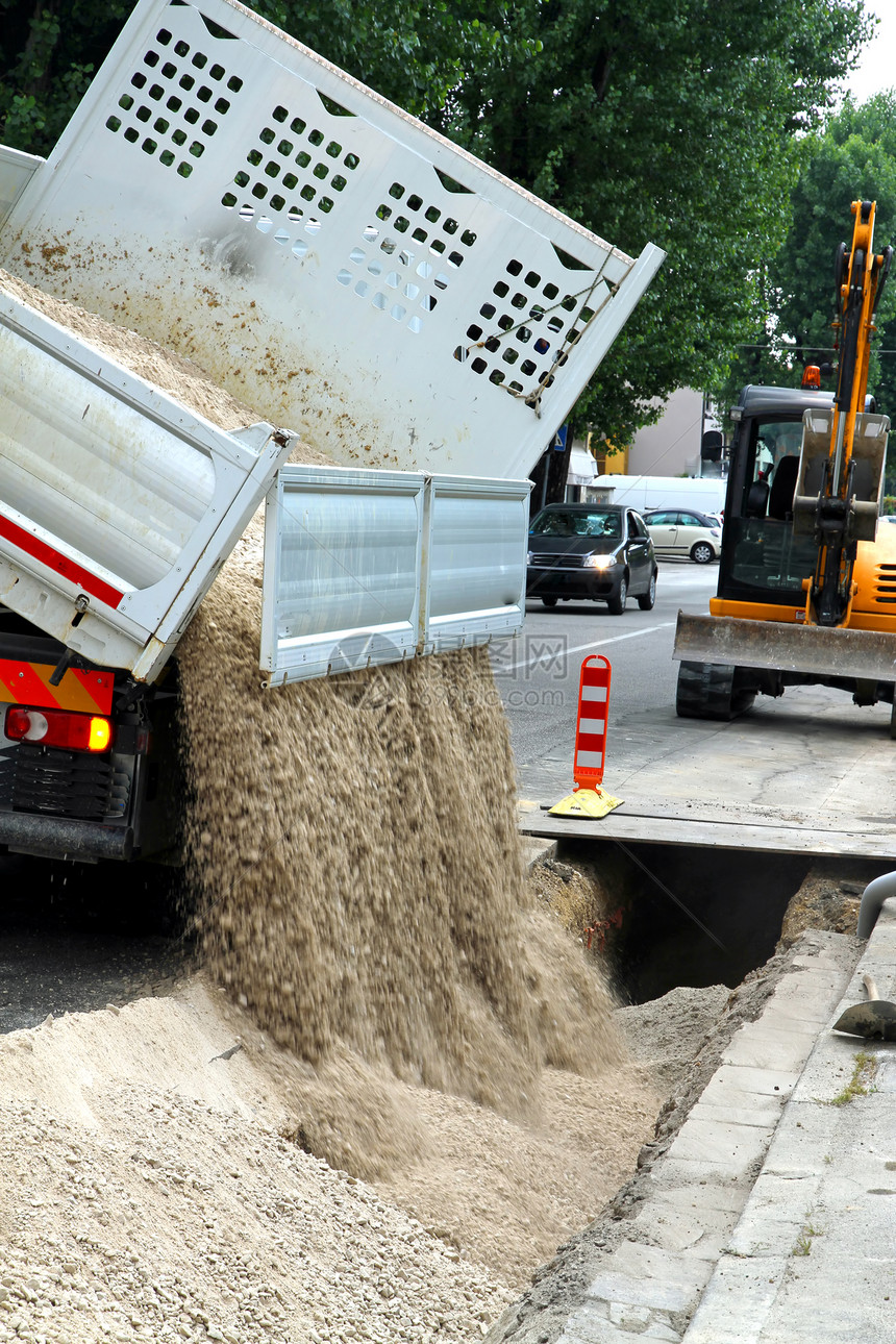 在挖掘铺设光纤管道煤气管道过程中清理砂砾路时的卡车小便器图片