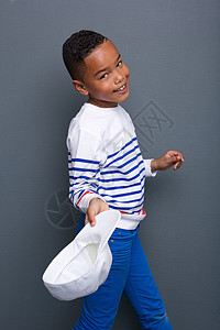 一个可爱的小黑男孩的肖像笑着带灰色背景图片