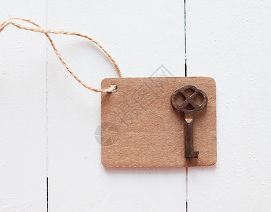 白色木板上粗绳和生锈的古董钥匙上的空图片