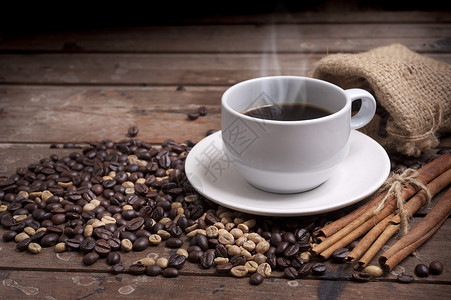 木桌上的咖啡杯和茶托深色背景图片