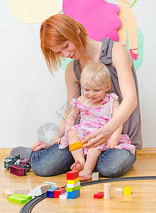 小女孩和她妈坐在地上玩铁道游戏图片