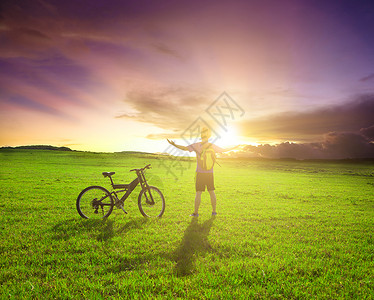 站在日落背景的自行车图片