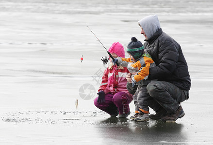 父亲教他的孩子在冬天在一个冰图片