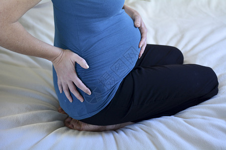 孕妇患有背部疼痛怀孕妇生活方式和保健的概念照图片