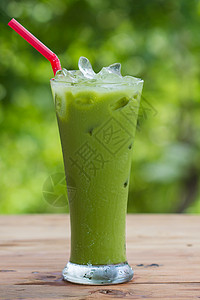 在绿色背景的玻璃杯中的绿茶图片