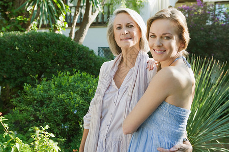 一个成年女儿和她成熟的母亲在家庭花园里享受彼此的陪伴图片