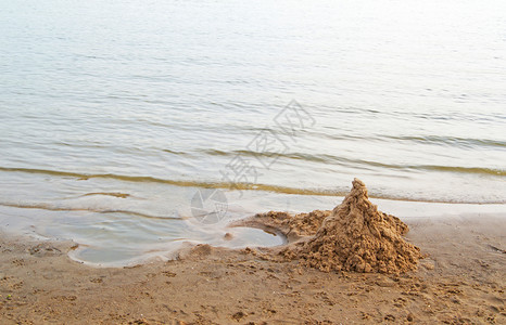 一堆干净的沙子形状像海滩上的一座城堡图片