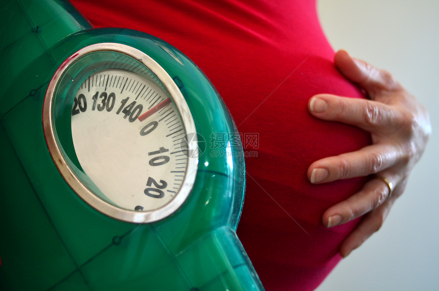 孕妇在怀孕期间持有体重秤怀孕妇生活方式和保图片