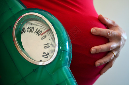 孕妇在怀孕期间持有体重秤怀孕妇生活方式和保图片