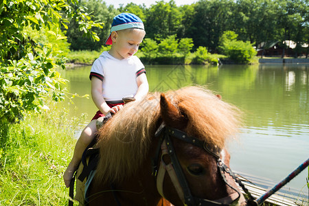 男孩骑着小马在大自然中图片