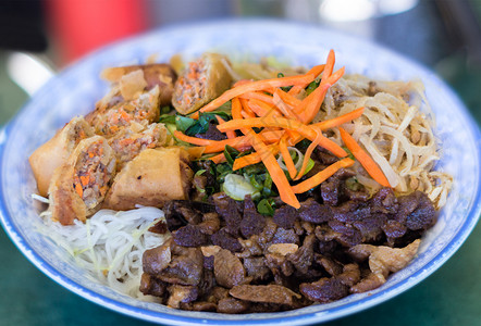 传统一碗越南面包粉丝米粉沙拉配炭烤肉猪肉丝油炸春卷和腌胡萝卜图片