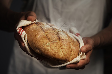 拿着一个的面包的贝克人图片