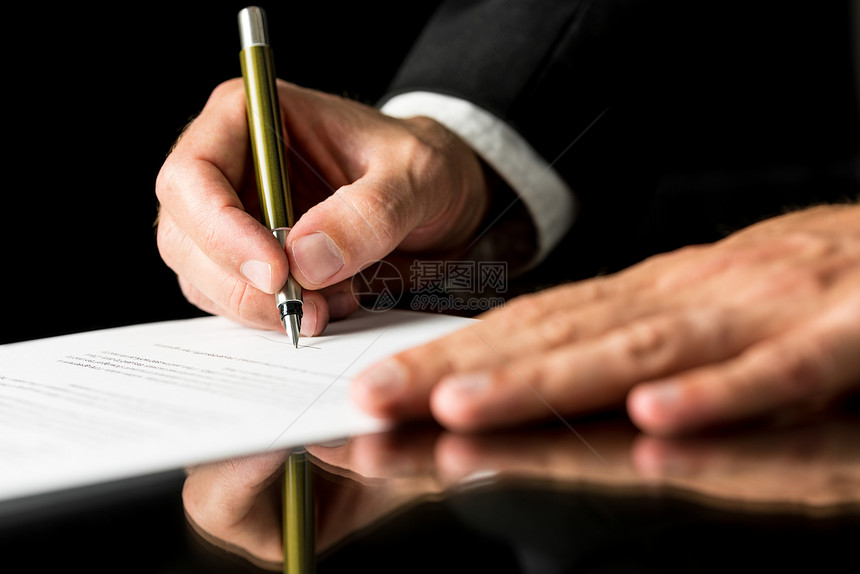 男手在黑桌子上用反射方式签署法律或保险文件图片
