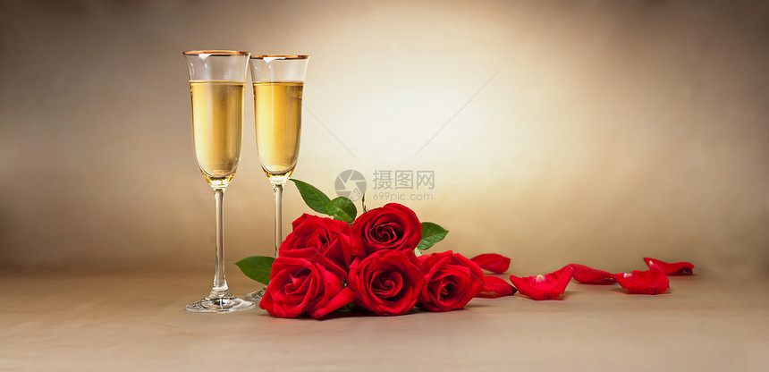 米色背景前的香槟杯礼物和玫瑰图片