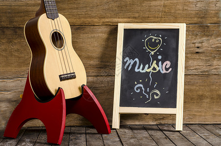 Ukulele吉他和黑板用木制背景图片