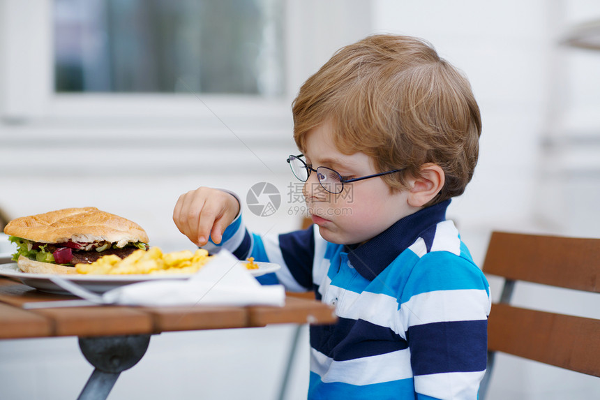 可爱的小男孩吃快餐咖啡厅图片