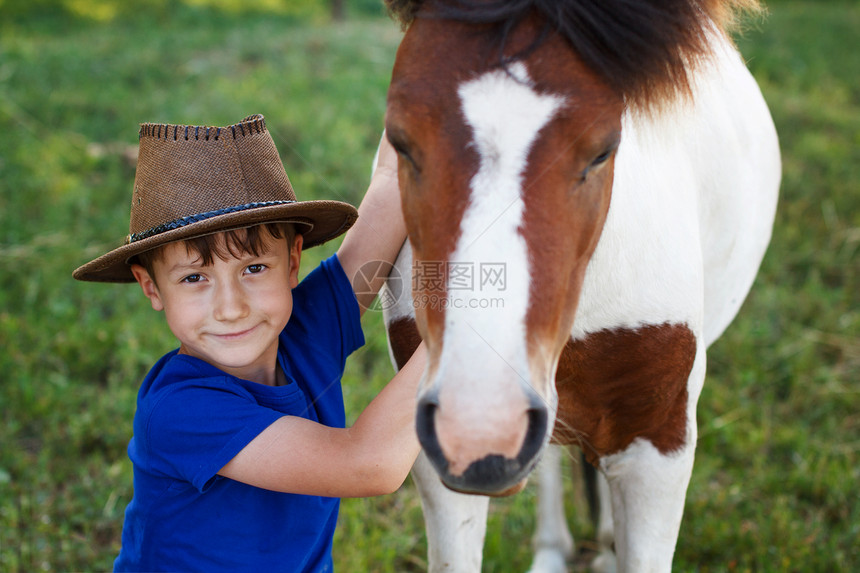 戴牛仔帽和小马的小男孩图片