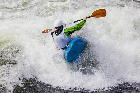活跃的男Kayaker滚动和冲浪图片