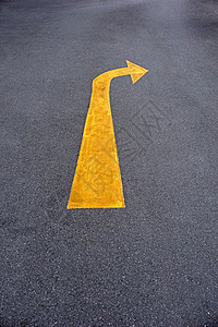 在柏油路的黄色交通箭头标志图片