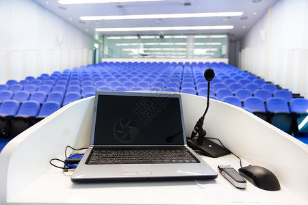 用蓝色天鹅绒椅子在空会议厅讲台上的讲台上用笔记本图片