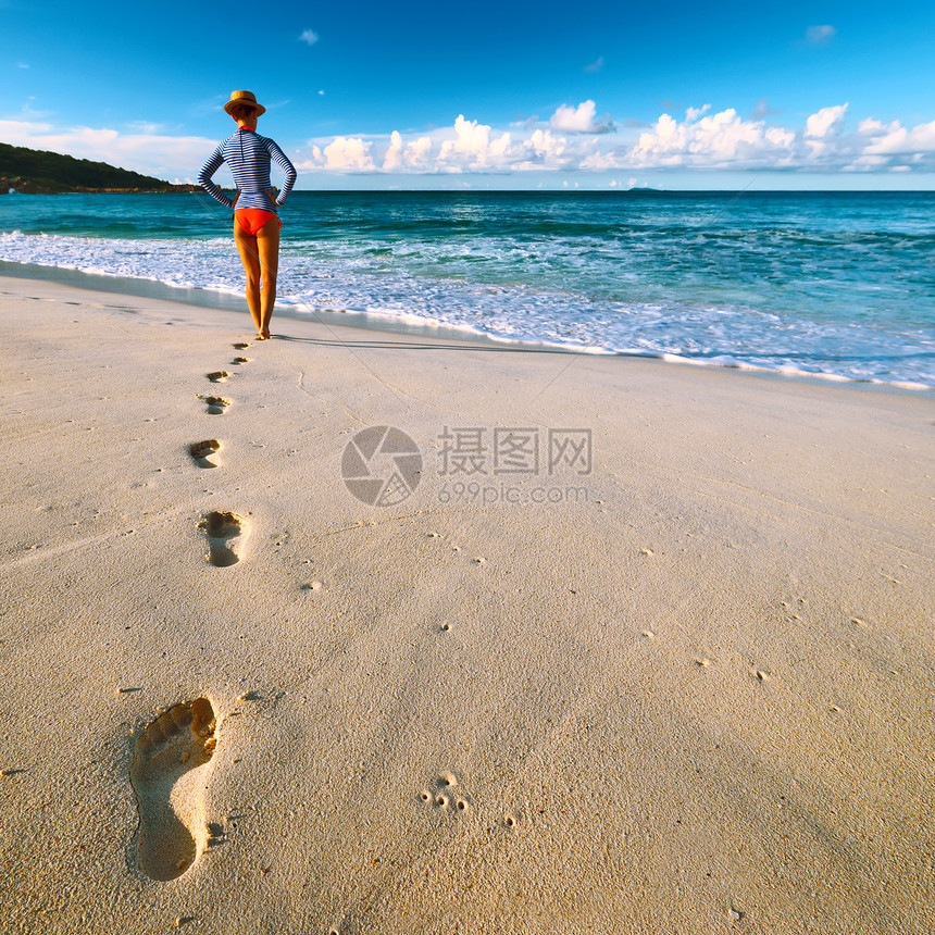 塞舌尔美丽的海滩上的女人在沙滩上行图片