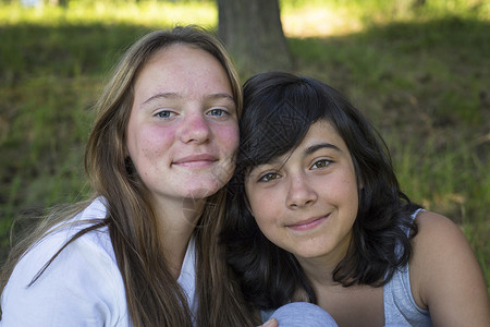 两个小女孩坐在公园的草地上图片