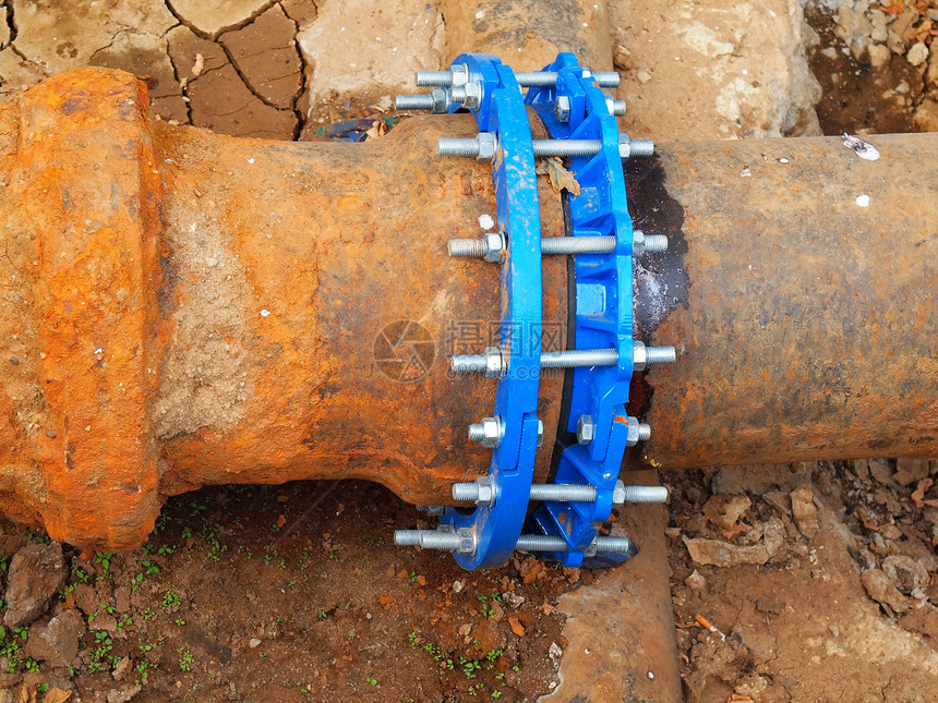 旧的大饮用水管与新的蓝色螺纹接头构件相连完成修复管道等待粘土覆盖极端的那种腐蚀图片